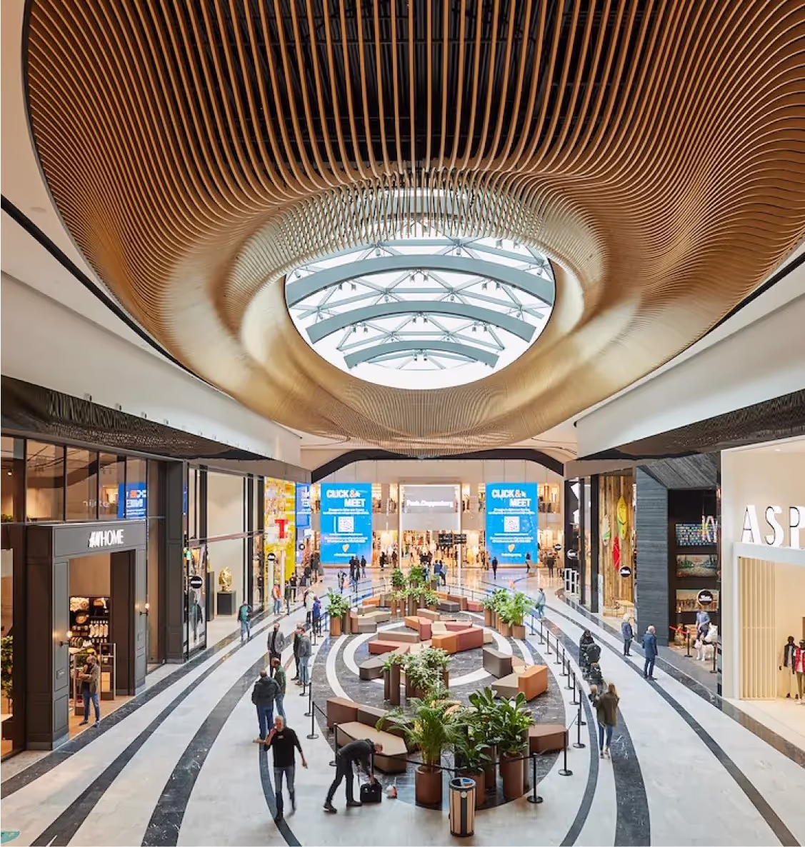 Modern winkelcentrum met futuristisch plafondontwerp en shoppers.