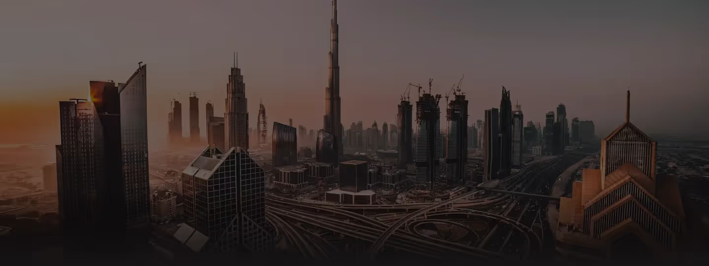 Luchtfoto van de stadsachtergrond van Dubai bij zonsondergang met Burj Khalifa en meerdere hoge gebouwen en snelwegen.